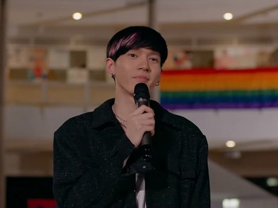 Max gives a speech at an LGBTQ+ event.