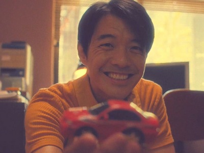 Zheng-yuan smiles as he gives a toy car to his son.