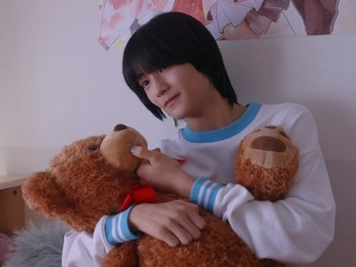 Kakeru hugs a teddy bear in his sister's room.