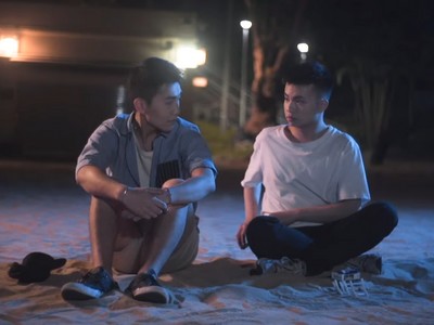 Yiu and Hin sit on the beach and talk.