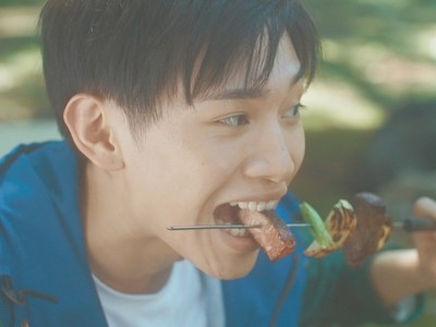 Kazuhiro eats a grilled skewer.