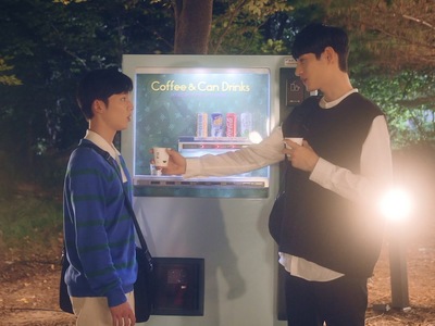 Roa gives Ji Woo a can of coffee by the vending machine.