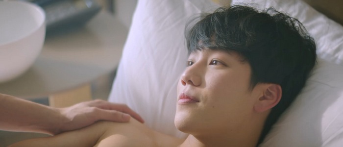 A shirtless Mark lies in bed in Love Mechanics Episode 6.