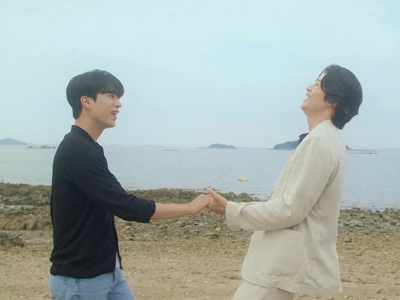Do Gun and Jung Woo hold hands on the beach.