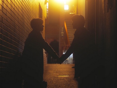 Nozue and Togawa hold hands in the alleyway.