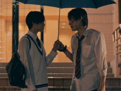 Jin and Haruki hold an umbrella in the rain.