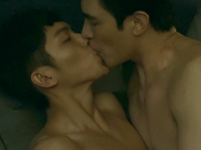 Damian and Jerry kiss shirtless in bed.