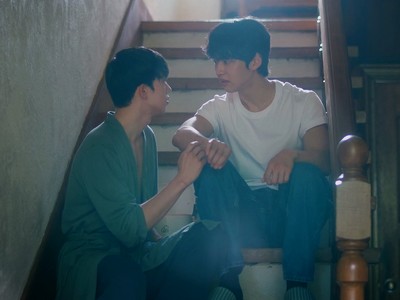 Yihyun and Jaeon sit on the stairs.