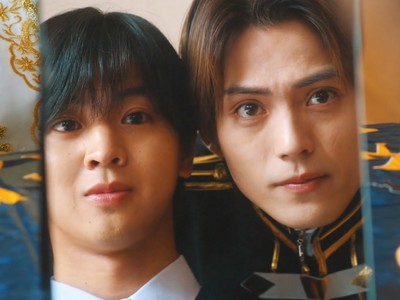 Hioki and Watari look into a mirror reflection.