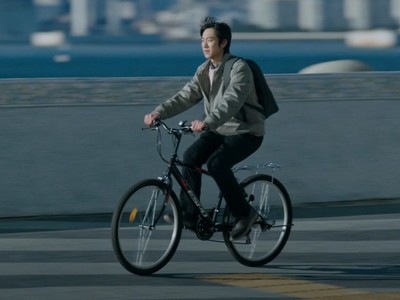 Dong Joon rides a bicycle.