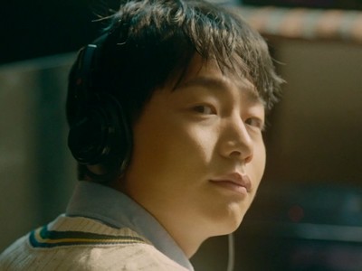 Kang Hyun listens to music while looking at his friend.