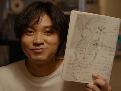 Ryu smiles at a picture of himself.