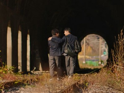 Hotae and Donghee enter a railway tunnel.