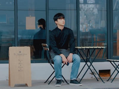 Ji Woo sits in the restaurant by himself.