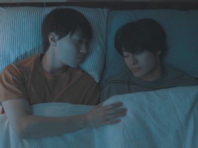 Kazuma stares lovingly at a sleeping Ren in bed.